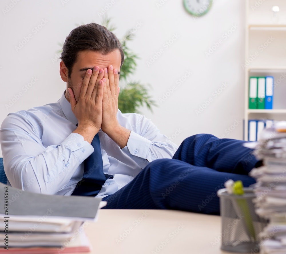 Young male businessman employee unhappy with excessive work Young male businessman employee unhappy with excessive work