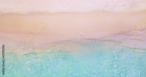 Aerial view of sea crashing waves White foaming waves on beach sand,Top view beach sea surface texture background,Amazing colorful beach sea wonderful sand background