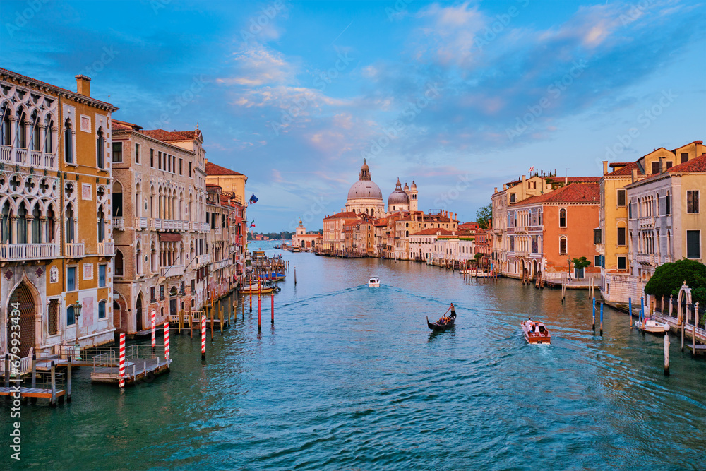 Panorama of Venice Grand Canal with boats and Santa Maria della Salute church on sunset from Ponte dell'Accademia bridge. Venice, Italy