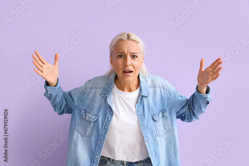 Upset mature woman on lilac...