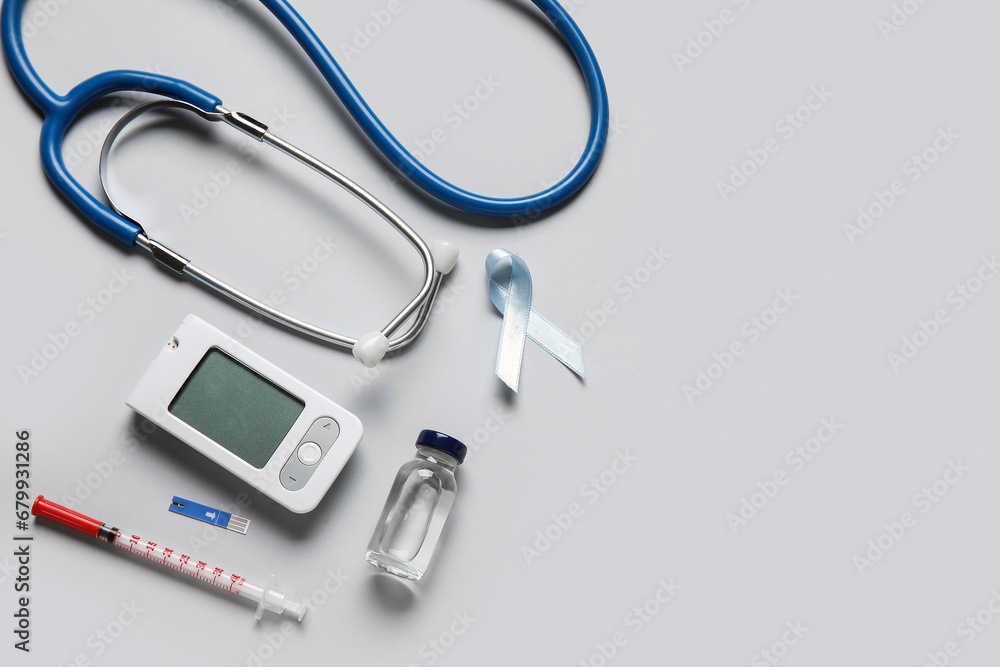 Awareness ribbon with insulin, glucometer and stethoscope on light background. Diabetes concept Awareness ribbon with insulin, glucometer and stethoscope on light background. Diabetes concept
