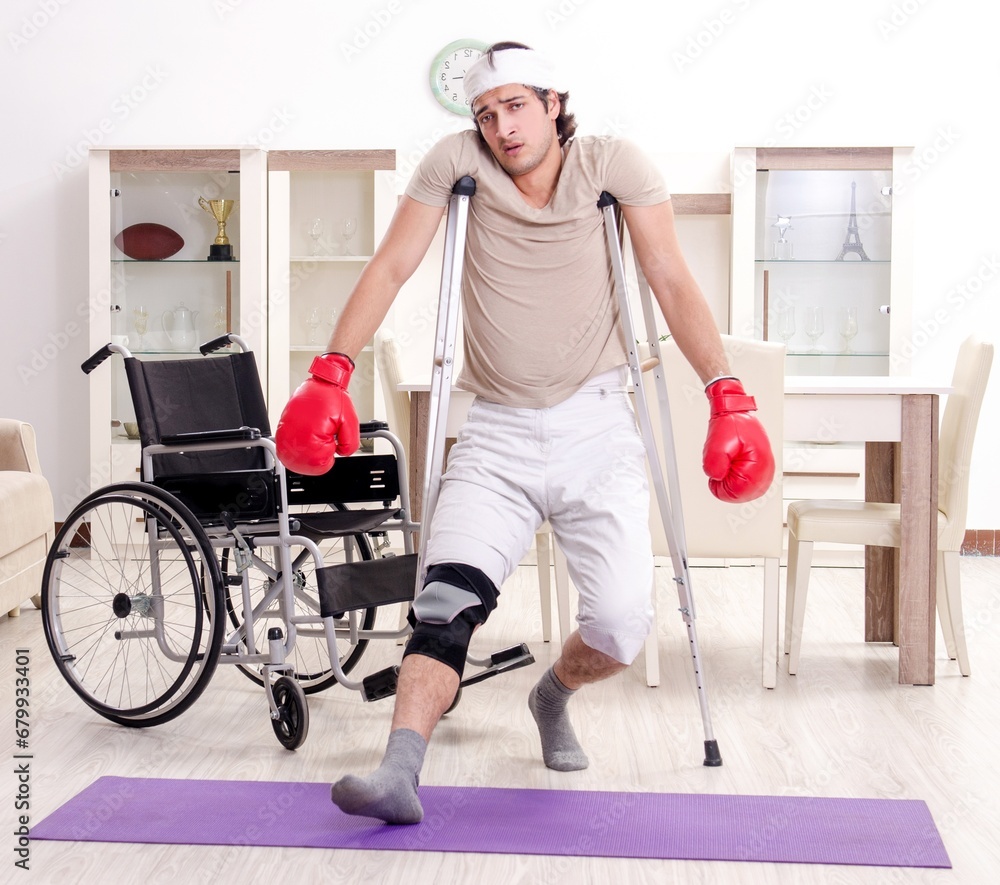 Injured young man doing exercises at home Injured young man doing exercises at home