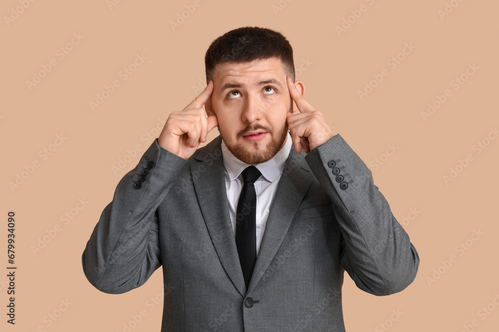 Young thoughtful businessman on beige background. Business idea concept Young thoughtful businessman on beige background. Business idea concept