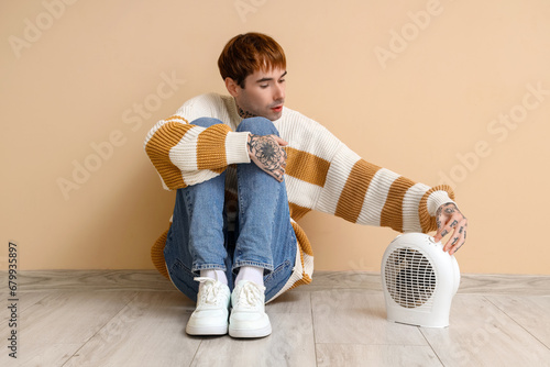 Young man with electric fan...