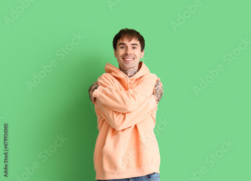 Young man hugging himself o...