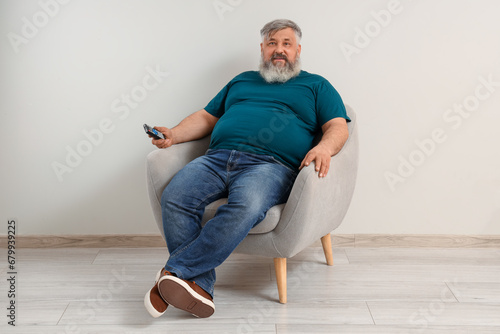 Mature man watching TV in a...