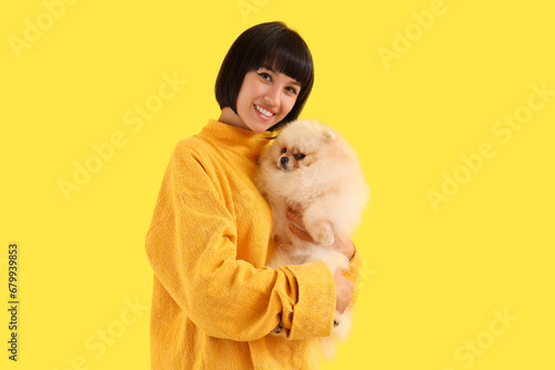 Young woman hugging Pomeran...