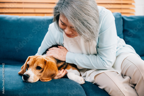 In their cozy living room, an old lady and her Beagle puppy share warm moments on the sofa. Their friendship and happiness create a haven of love and warmth in this heartwarming pet portrait.