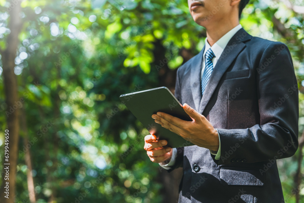Business man using tablet to analyze Renewable energy generation is essential for the future. Renewable energy-based green business can limit climate change and global warming. Business man using tablet to analyze Renewable energy generation is essential for the future. Renewable energy-based green business can limit climate change and global warming.