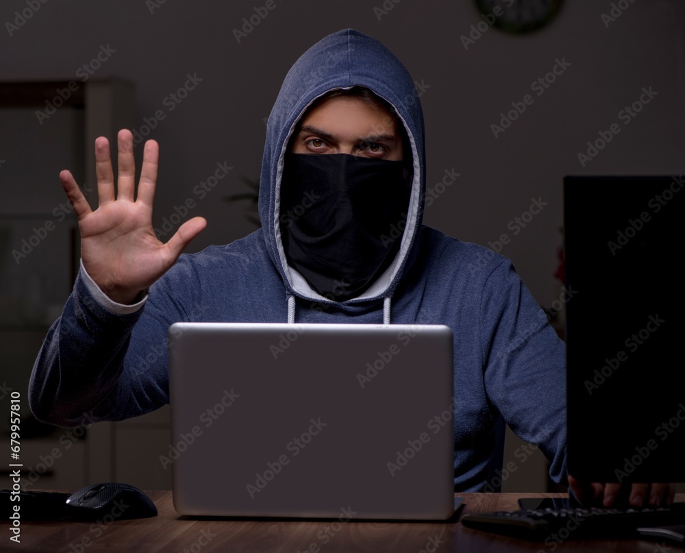 Male hacker hacking security firewall late in office Male hacker hacking security firewall late in office