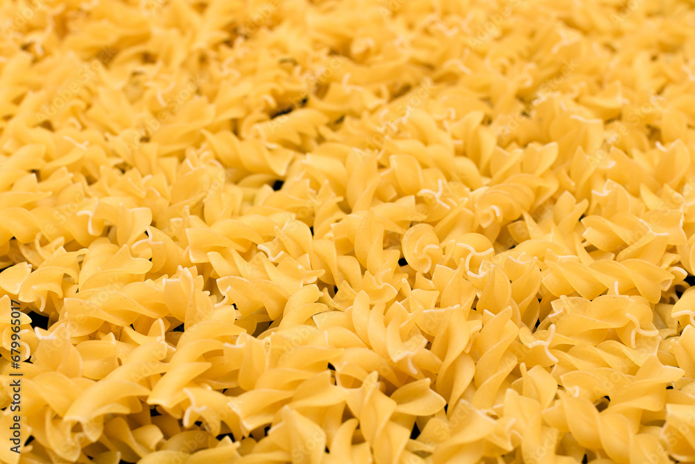 Uncooed Fusilli Pasta - Background. Texture of Bright Golden Dry Macaroni Uncooed Fusilli Pasta - Background. Texture of Bright Golden Dry Macaroni