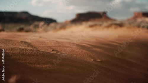 Grains of sand blowing in the desert wind during sunset photo
