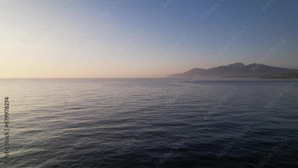Cinematic aerial view of the coast of the island. Crystal clear breaking ocean wave with waving waterline. Sunrise over calm sea. Dawn over horizon in Bali Cinematic aerial view of the coast of the island. Crystal clear breaking ocean wave with waving waterline. Sunrise over calm sea. Dawn over horizon in Bali
