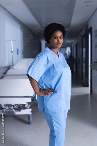 Portrait of african american female doctor standing in hospital corridor with copy space