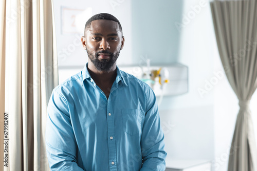 Portrait of african american male doctor in sunny hospital room