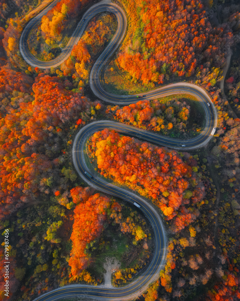 Curvy mountain roads in autumn. Vehicles in motion on winding mountain roads.