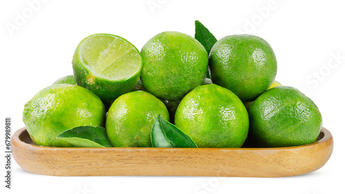 Green lime fruits with leaves in a wooden plate isolated on a white background
