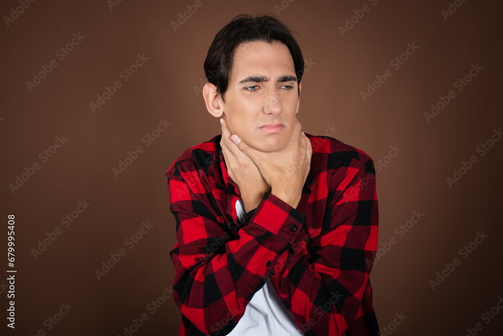 Christmas and New Year. A young attractive guy waiting for the holidays. Brown background. Christmas and New Year. A young attractive guy waiting for the holidays. Brown background.