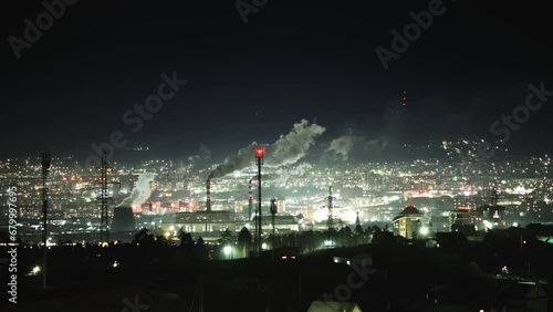 night lights of industrial zone with smoking pipe , with film grane