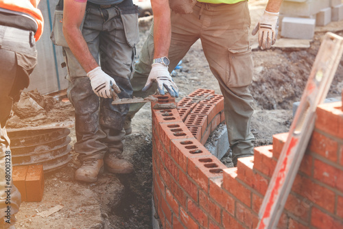 Cuadro en lienzo Industrial bricklayer laying bricks on cement mix  on a curved wall