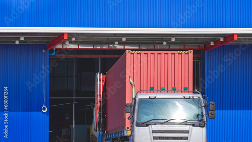 Obraz na plátně Semi trailer truck is being unloading construction equipment into new warehouse
