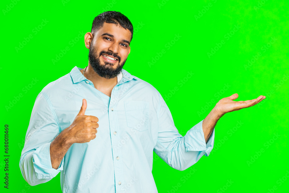 Indian bearded man showing thumbs up and pointing right empty place, advertising area for commercial text copy space for goods promotion advertisement. Guy isolated on chroma key background. Lifestyle Indian bearded man showing thumbs up and pointing right empty place, advertising area for commercial text copy space for goods promotion advertisement. Guy isolated on chroma key background. Lifestyle