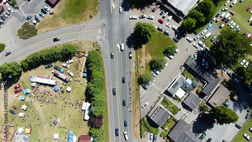 Drone top-view video showcasing a highway intersecting with a road, surrounded by numerous parked cars in a rural area with green trees, in Bodega Bay, Gualala Coast, California. photo