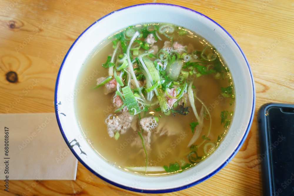 Vietnamese Pho dish and smartphone on the table Vietnamese Pho dish and smartphone on the table