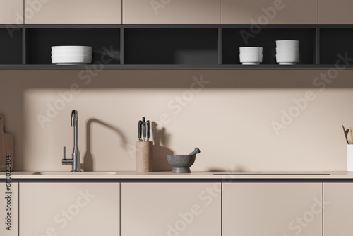 Beige home kitchen interior with cabinet, sink and kitchenware on counter