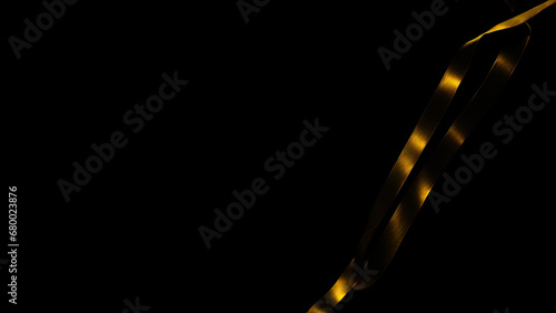 Gold ribbon on black background. Copy space for text.
