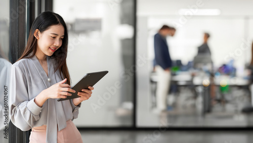 Young happy business woman working with tablet in corporate office