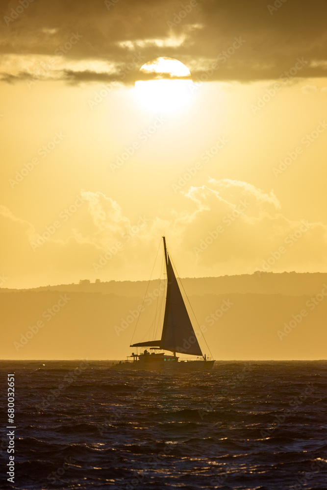 Fototapeta premium Boat sailing on the sea in sunset in front of Sun
