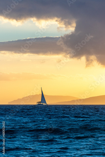 Sailboat sailing in the ocean during sunset © Evgeny Katyshev