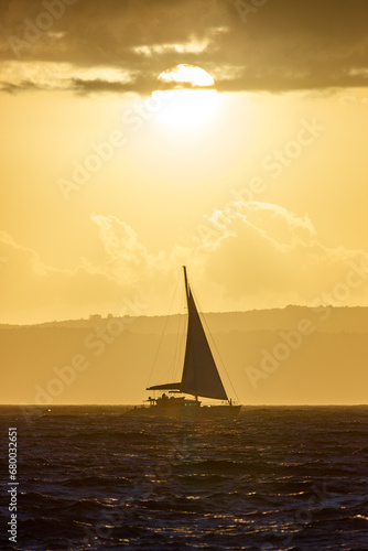 Boat sailing on the sea in sunset in front of Sun
