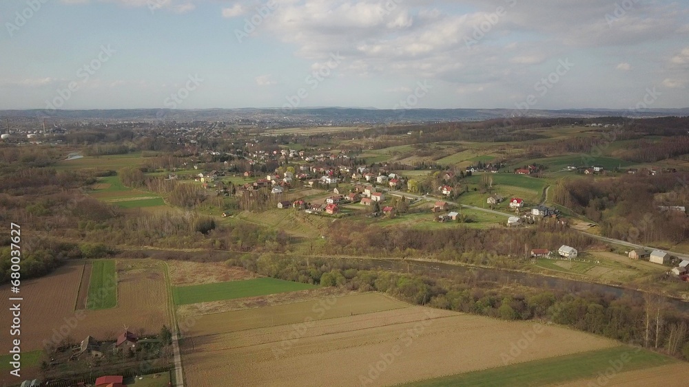 Panorama from a bird's eye view. Central Europe: The Polish village is located among the green hills. Temperate climate. Flight drones or quadrocopter. Urbanization of the landscape