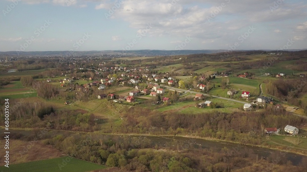 Panorama from a bird's eye view. Central Europe: The Polish village is located among the green hills. Temperate climate. Flight drones or quadrocopter. Urbanization of the landscape