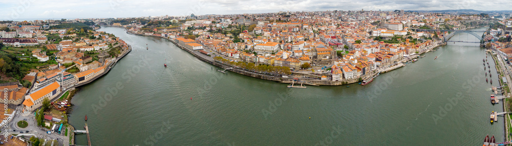 Panoramic aerial view of Porto city. View of Douro River. At right is Dom Luis I Bridge, at left Ponte da Arrabida. Panoramic perspective of old town center. Cloudy day. Famous travel destination. 