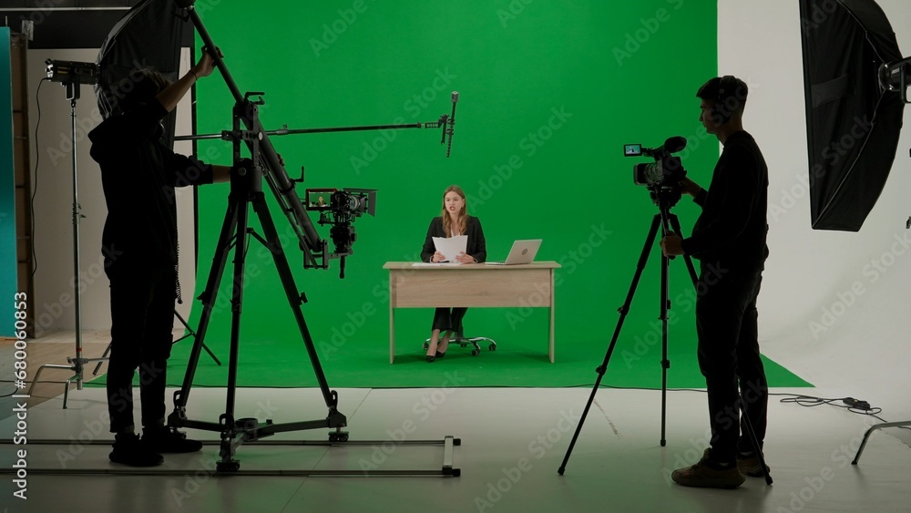 Φωτογραφία News anchor at work, woman journalist presenter telling breaking news, view of a backstage studio TV news shooting, chroma key template