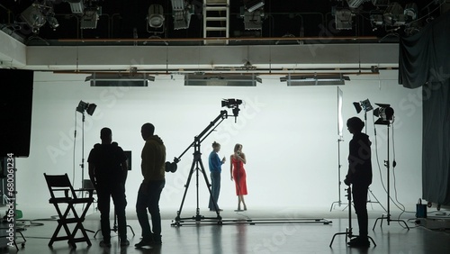 Professional filming pavilion with a white cyclorama. The process of preparing for the shooting of a music video. Director, Cameraman and crew in Backstage. photo