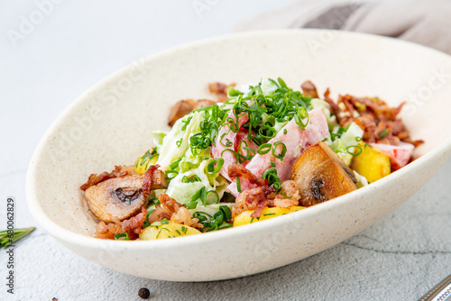 salad with potatoes, rice, meat and green onions side view