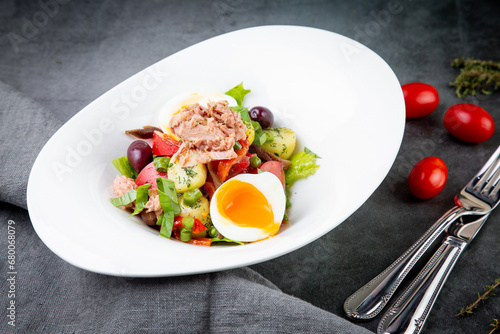 salad with soft-boiled egg, tuna, green onions, boiled potatoes, side view