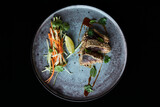 Présentation gastronomique d'un takati de thon rouge au sésame sur assiette avec légumes