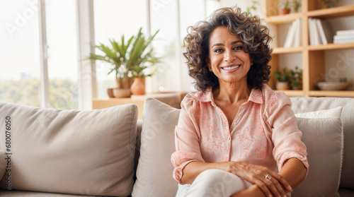 Senior latina woman happy sitting on her sofa in the living room at home, smiling retired pensioner healthy mature woman hd photo