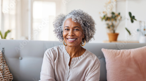 Senior african american woman happy sitting on her sofa in the living room at home, smiling retired pensioner, healthy mature black woman hd photo