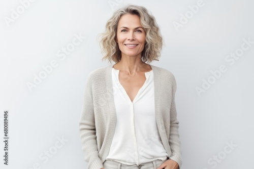 Portrait of a satisfied woman in her 40s wearing a chic cardigan against a white background. AI Generation photo