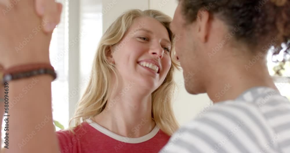 Happy diverse couple looking at each other and dancing at home, slow motion Happy diverse couple looking at each other and dancing at home, slow motion