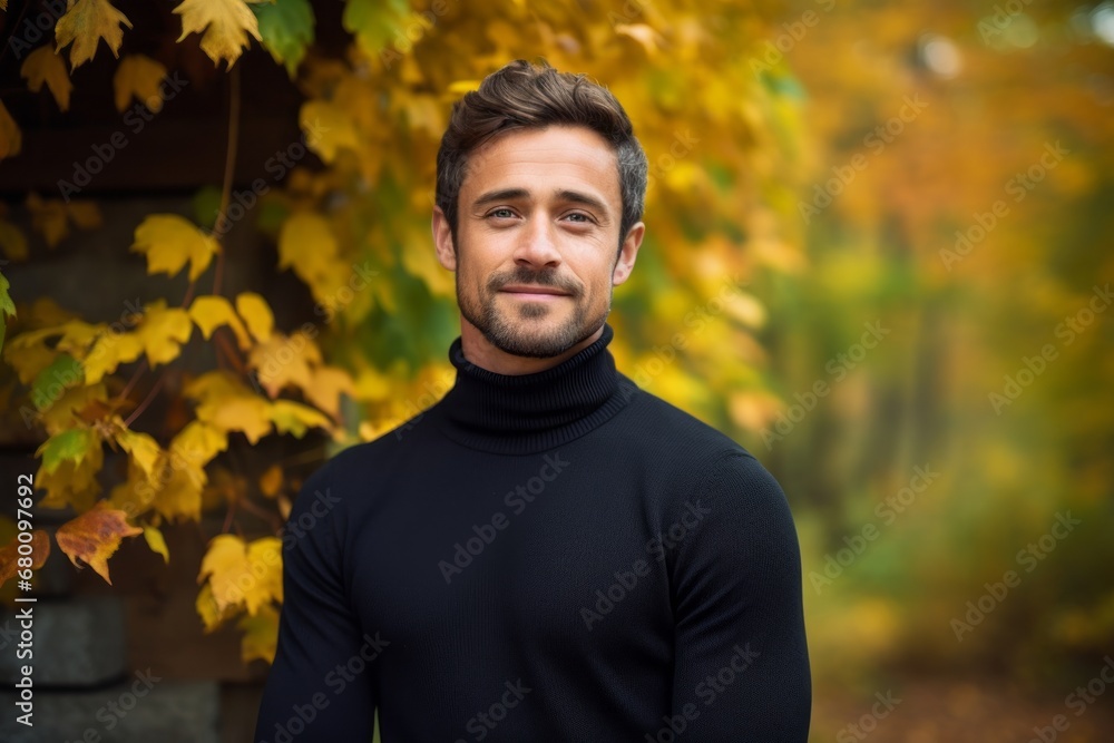 Portrait of a glad man in his 30s wearing a classic turtleneck sweater against a background of autumn leaves. AI Generation