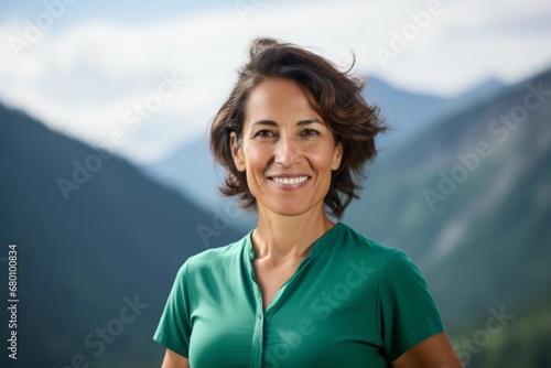 Portrait of a smiling woman in her 40s donning a classy polo shirt against a backdrop of mountain peaks. AI Generation