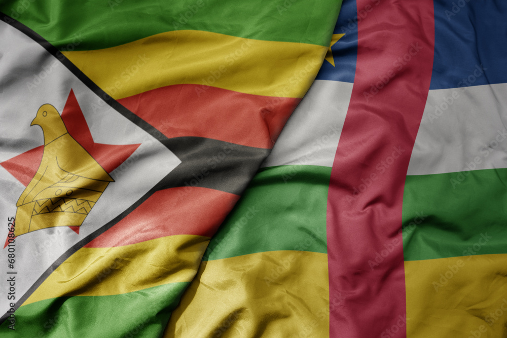 big waving national colorful flag of central african republic and national flag of zimbabwe .