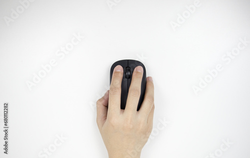 A business man’s hand holding the wireless mouse for working on computer. Computer device for work from home, work anywhere, work your way, gaming, shopping online.